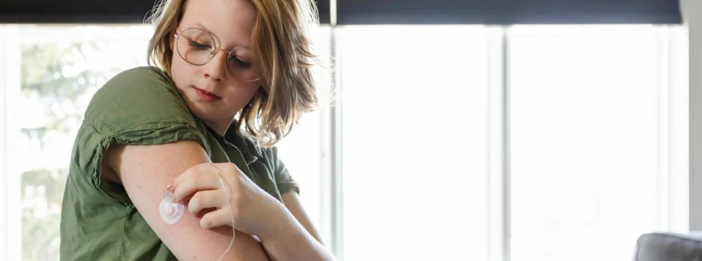 Patient adjusting a CGM (Continuous Glucose Monitoring) Patch on her arm.